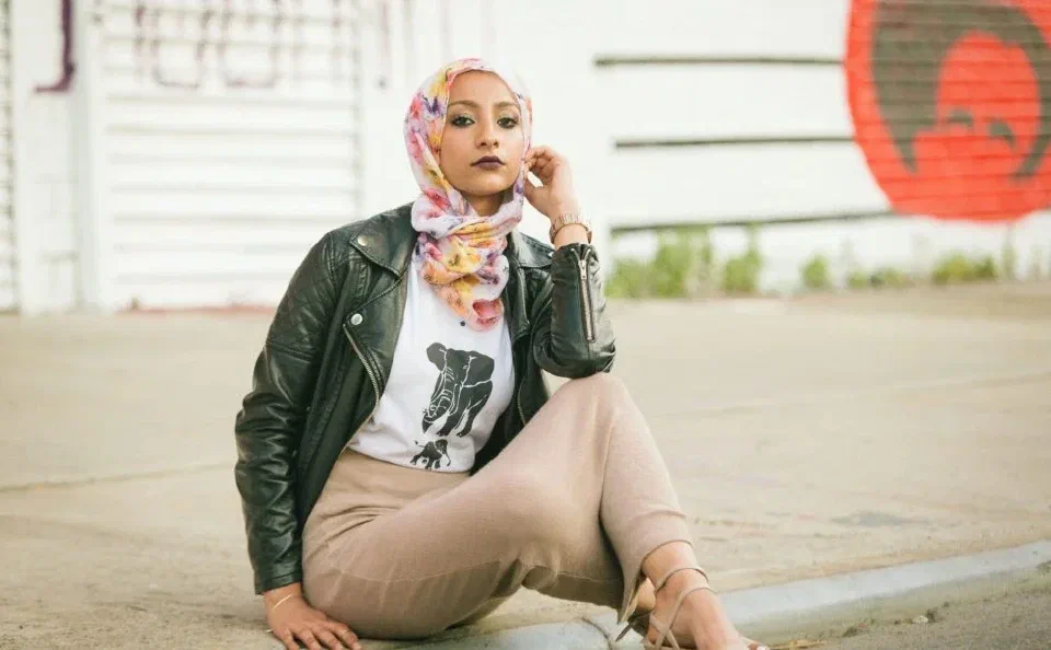 A young woman wearing a hijab, pensive